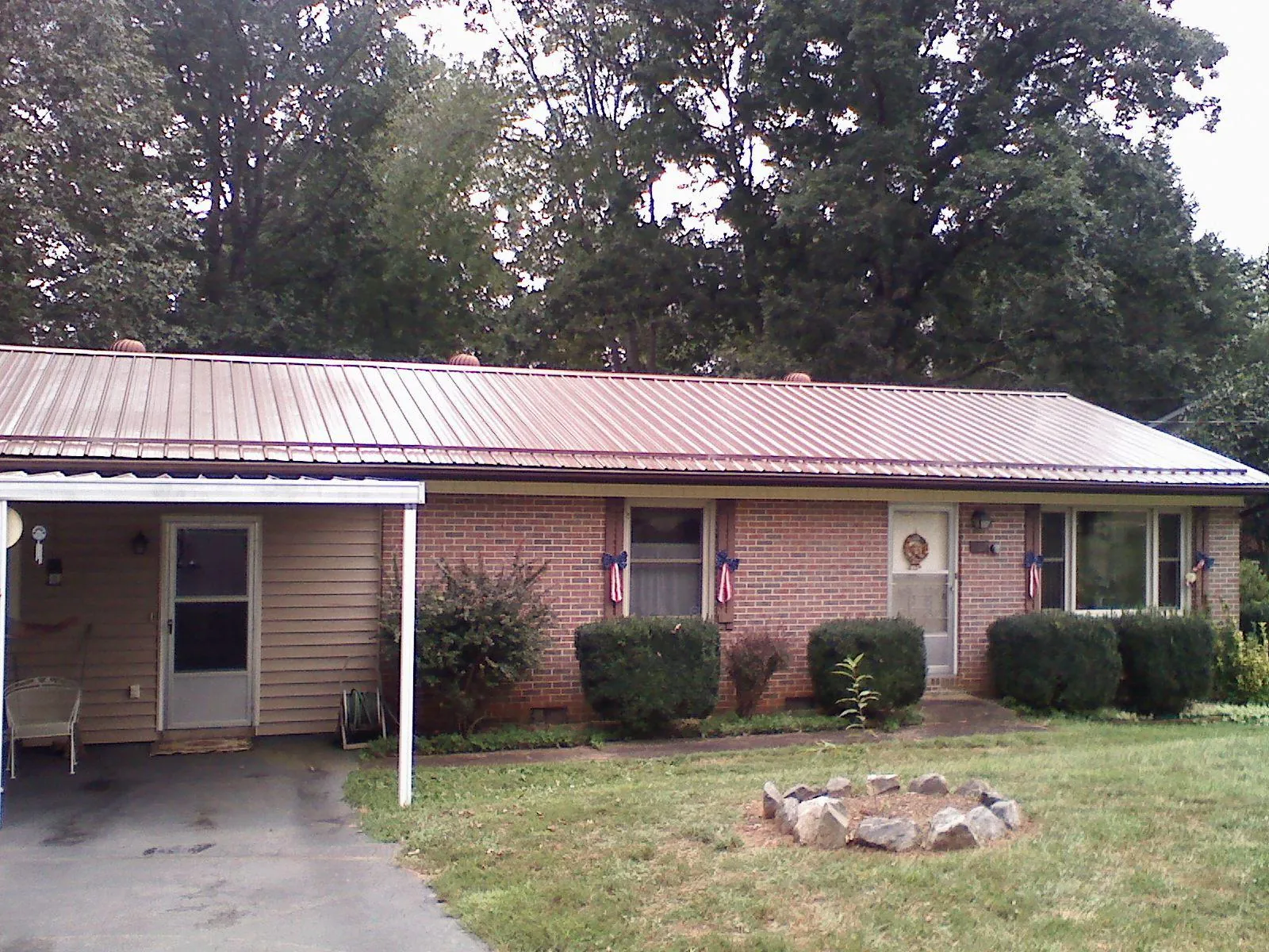 Bronze metal roof and carport on a brick ranch home — Roof Repair work by our crew in Bradner